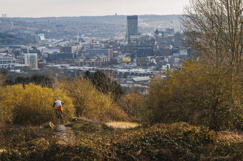 Rider on Parkwood Springs trail with views of Sheffield in the background